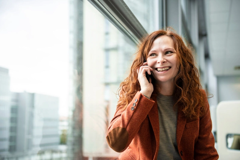 A smiling woman talks on her smartphone. - Markus Sommers / Business Finland A smiling woman talks on her smartphone. - Markus Sommers / Business Finland