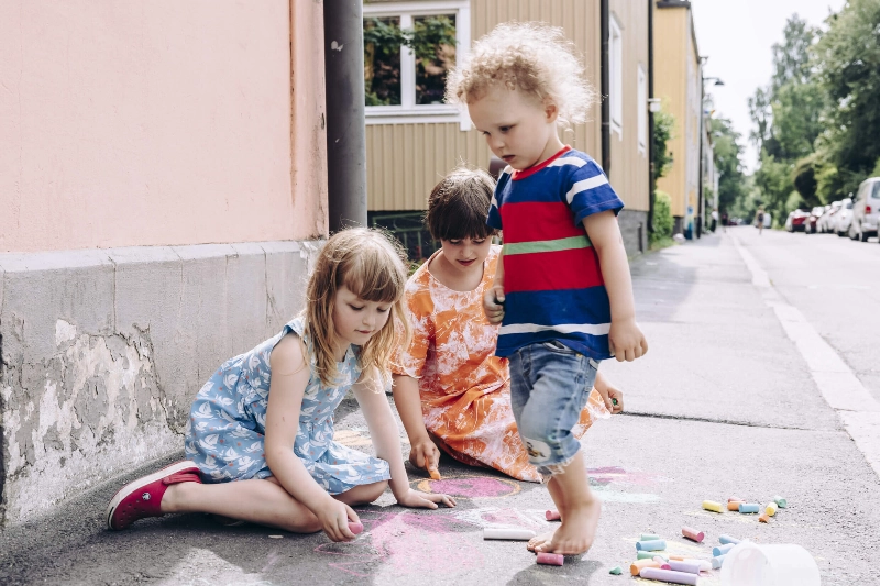 Three children draw with chalk. - Aleksi Poutanen / Helsinki Partners Three children draw with chalk. - Aleksi Poutanen / Helsinki Partners