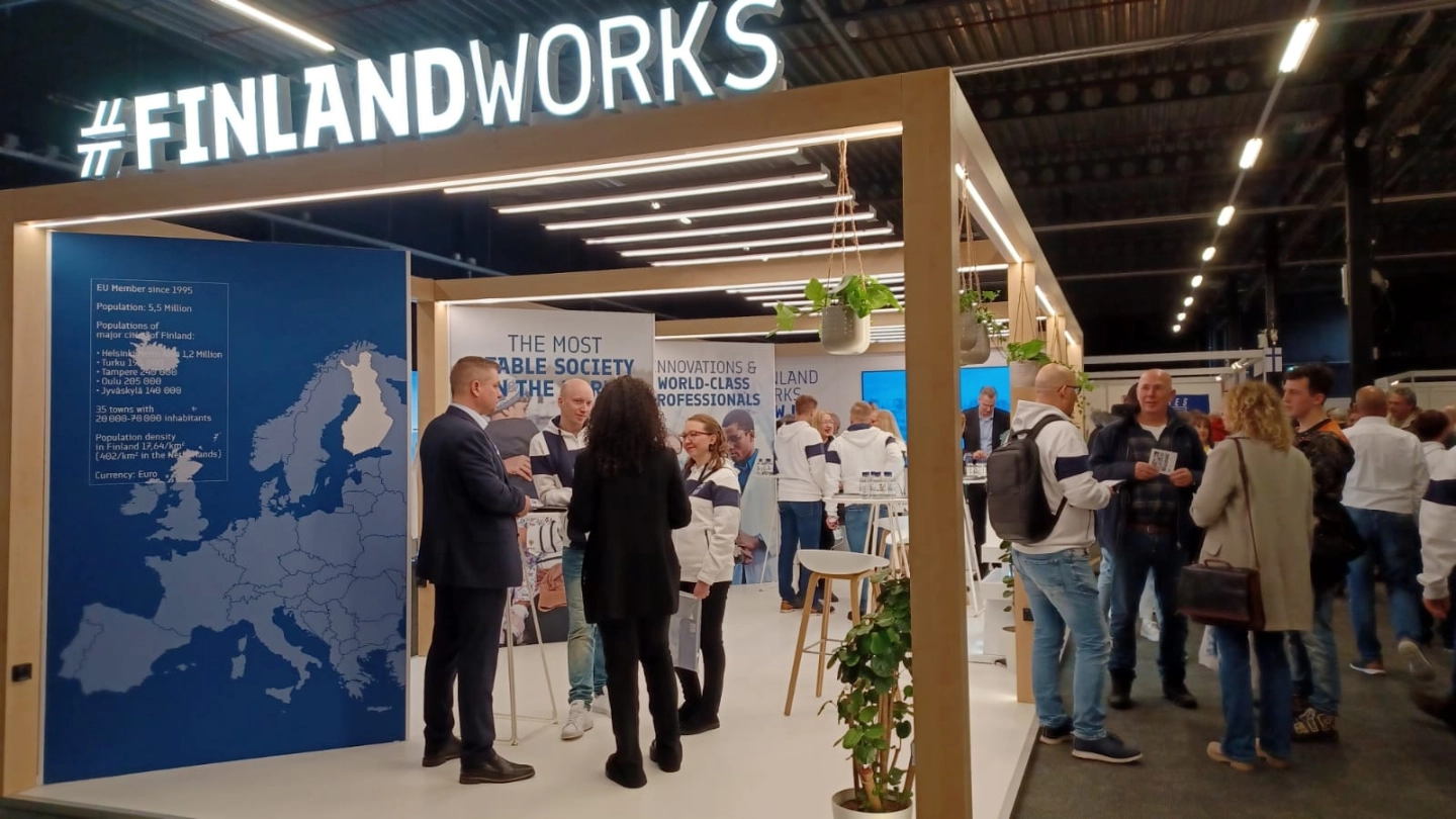 A group of people is standing at the exhibition booth. A group of people is standing at the exhibition booth.