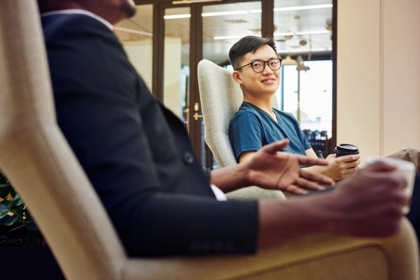 Two people sitting next to each other having a conversation - Business Finland Two people sitting next to each other having a conversation - Business Finland